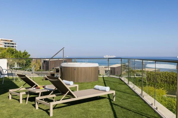 balkon met ligbedden en jacuzzi van suite bij Atlantica bay