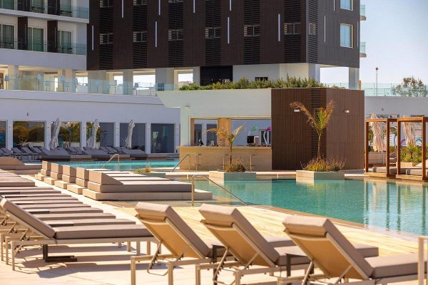Ligbedden en poolbar bij Chrysomare Beach Hotel