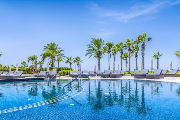 Zwembad met ligbedden bij Olympic Lagoon Resort paphos
